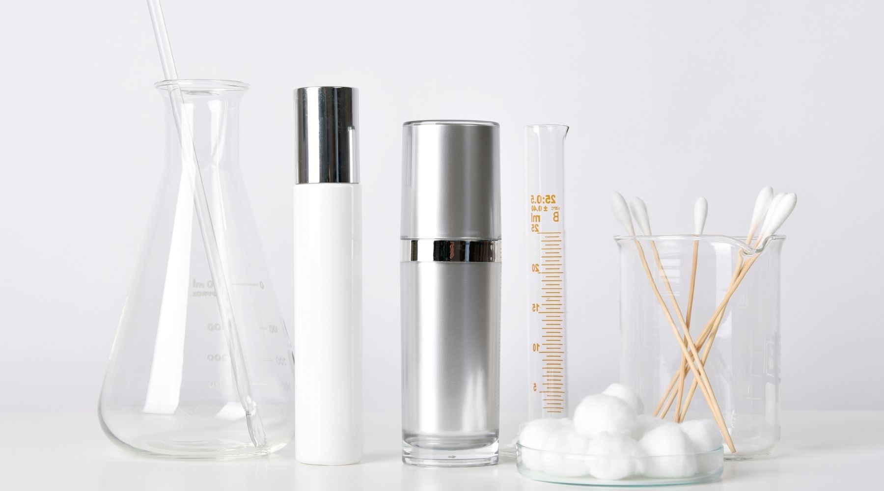 Imagen de laboratorio con frascos, pipetas y otros utensilios utilizados en la formulación de productos cosméticos.