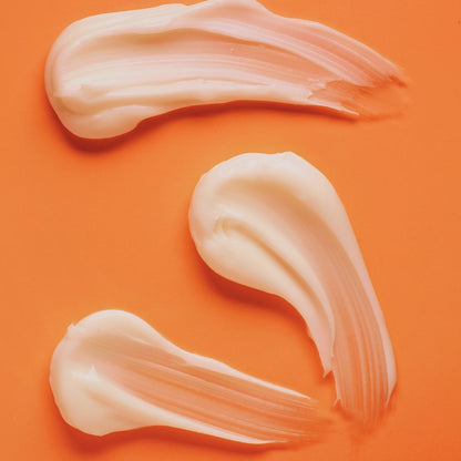 textura renovaglow shafacosmetics sobre fondo anaranjado. Textura crema color blanco