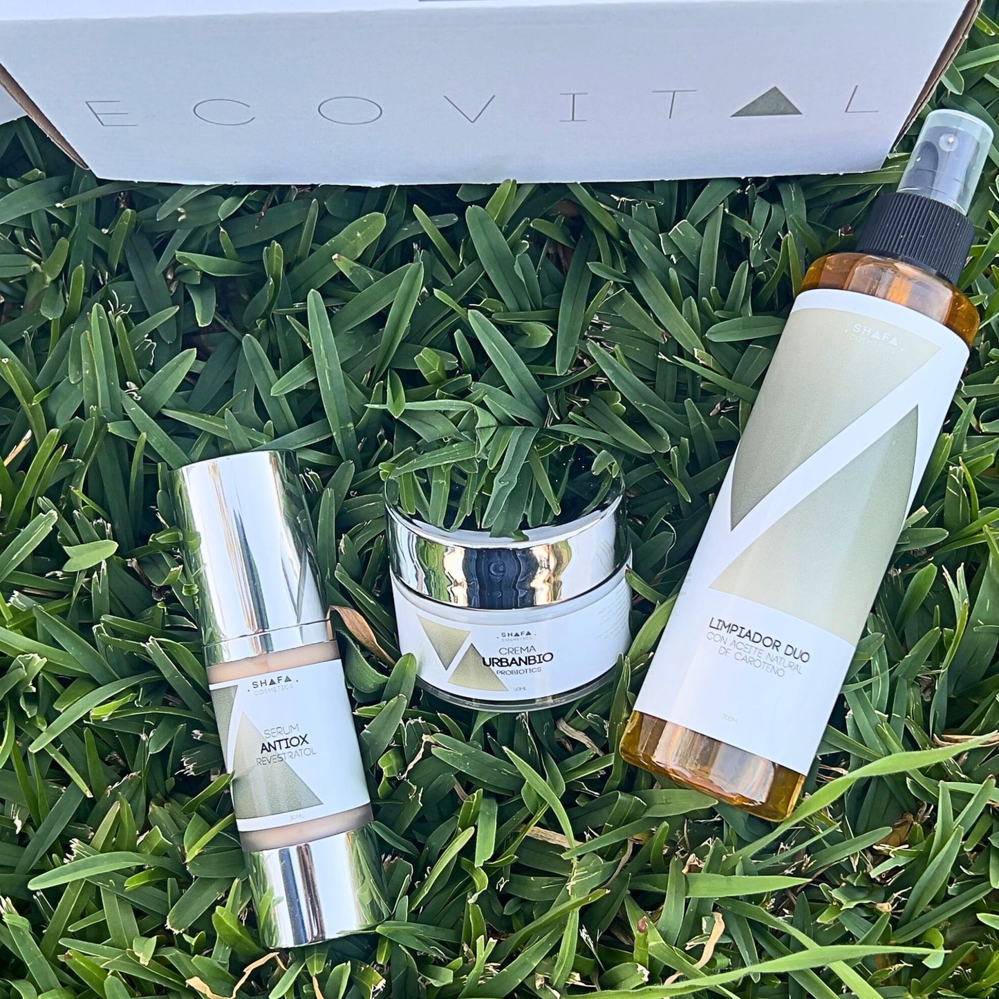 Imagen de 3 productos que forman parte del pack ecovital de shafa cosmetics sobre césped y de fondo la caja ecovital